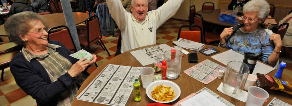 Rosedale, MD -- 2011 --  Bill James, 80, of Rosedale, center, celebrates after winning $95 in a "full card" game, as his wife Mary James, 76, left, and friend Thelma Sutphin, 68, of Middle River, look on, at VFW Post 6506. The VFW Post wanted to hold casino nights with card games and roulette to raise more money, if the legislature approved an expansion of gambling.  (Amy Davis / Baltimore Sun)